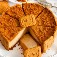 Pyszny sernik Lotus, pokrojony na kawałki, z ciasteczkami Lotus i pokruszonymi biszkoptami na wierzchu.