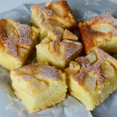 Puszyste ciasto z jabłkami i skyrem, posypane cukrem pudrem. Idealne na deser.