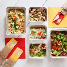 Różnorodne dania w pojemnikach, idealne na imprezę. Zastanawiasz się, ile kosztuje catering na 10 osób? Tu znajdziesz odpowiedź!