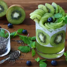 Zielony deser z kiwi i nasionami chia, wygląda jakby galaretka zaczyna tężeć.