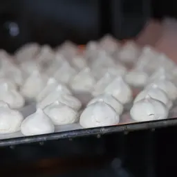 Bezy na blasze w piekarniku. Zastanawiasz się, dlaczego beza opada po upieczeniu? Oto potencjalne przyczyny.