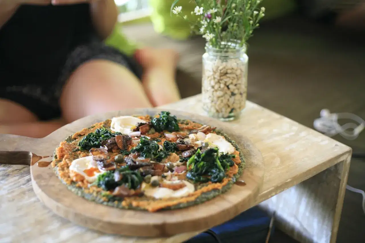 Zdrowy fast food: kolorowa pizza z warzywami i serem na drewnianej desce.