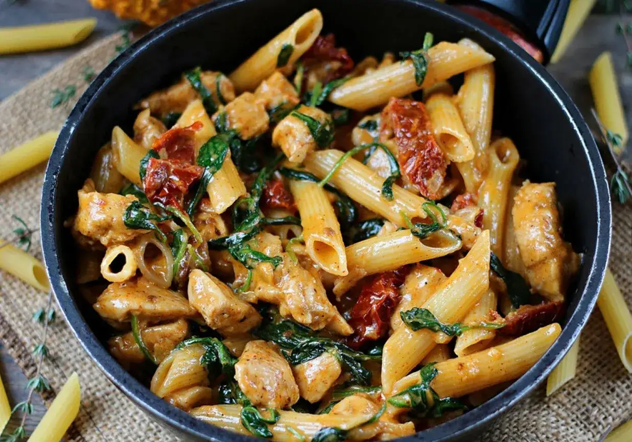 Penne z kurczakiem, szpinakiem i suszonymi pomidorami w kremowym sosie. Pyszny makaron z pesto i suszonymi pomidorami.