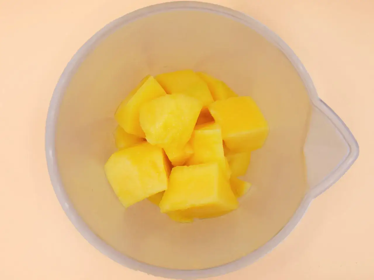 Kawałki mango w przezroczystej misce, idealne do sprawdzenia, czy mango z puszki nadaje się do galaretki.