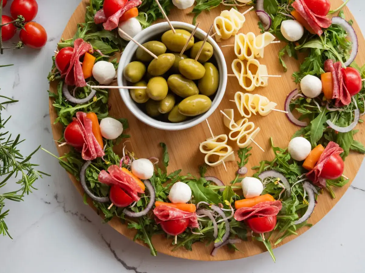 Oto inspiracja, jak ładnie podać koreczki: kolorowa deska z oliwkami, serem, salami, pomidorkami i rukolą.
