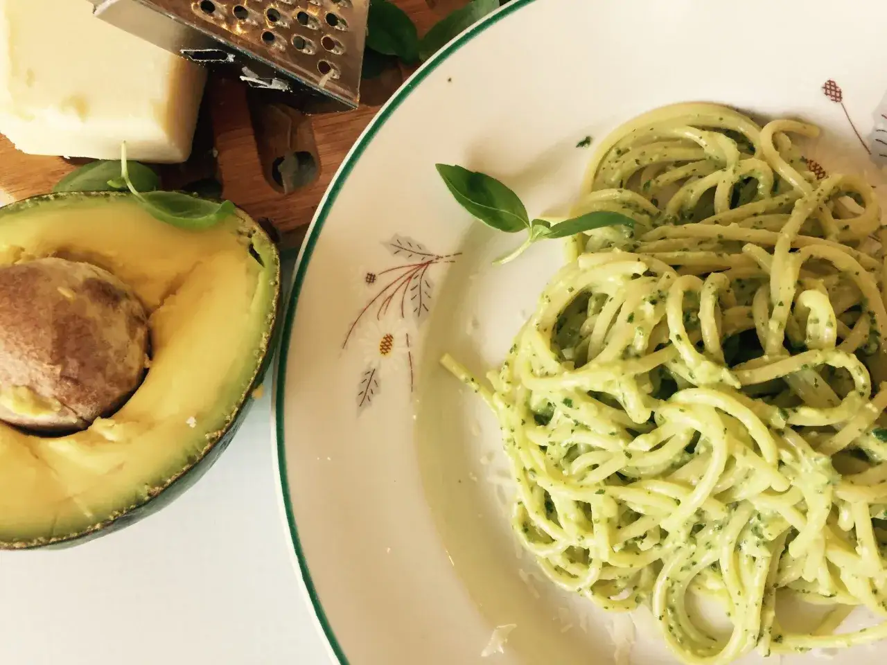 Makaron z kremowym pesto z awokado, świeża bazylia i kawałek parmezanu.