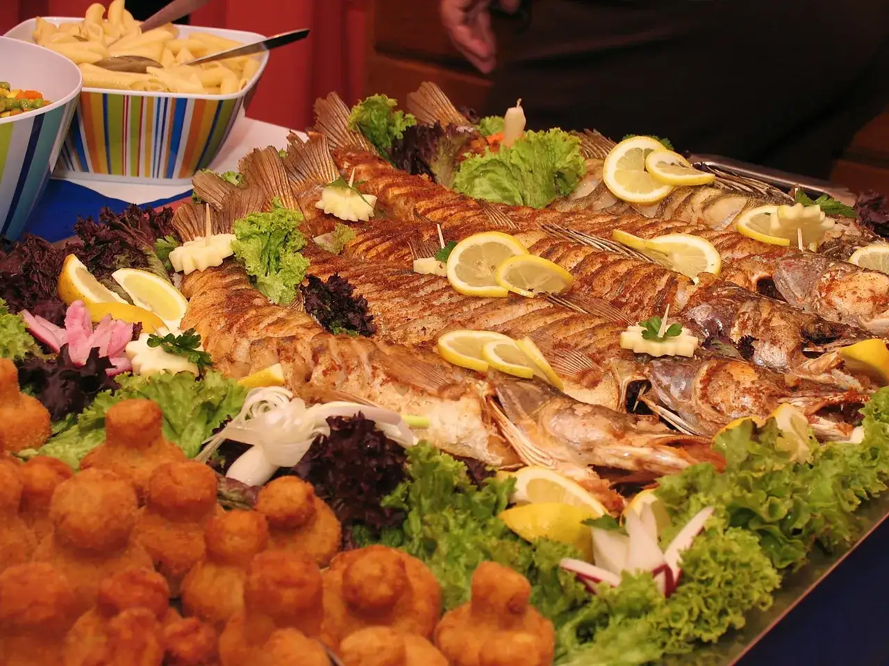 Bogaty wybór menu catering: pieczone ryby z cytryną, chrupiące kąski i makaron penne.