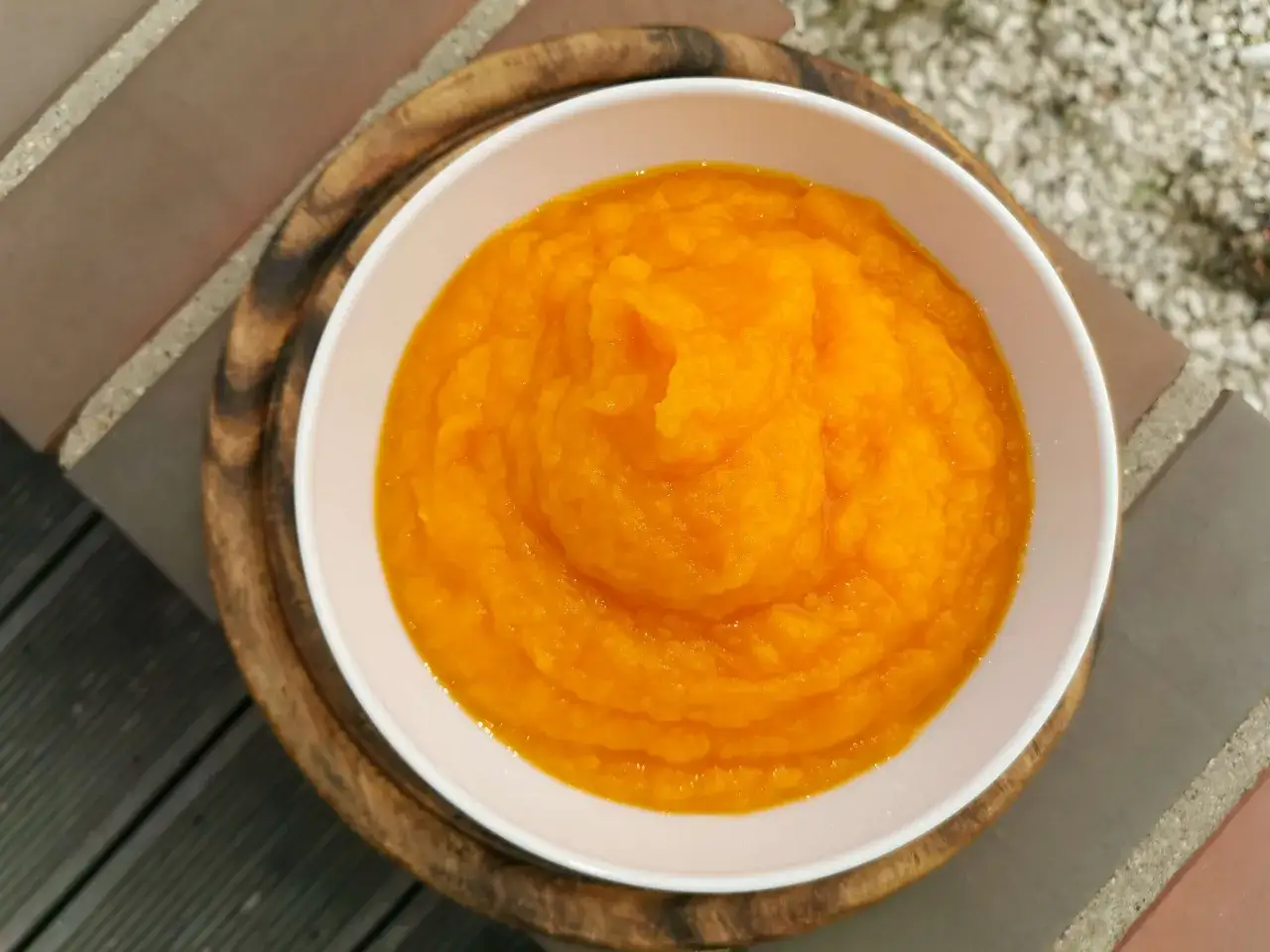 Gładkie, pomarańczowe puree z dyni w białej misce, idealne do przygotowania pysznych potraw. Oto jak zrobić puree z dyni.