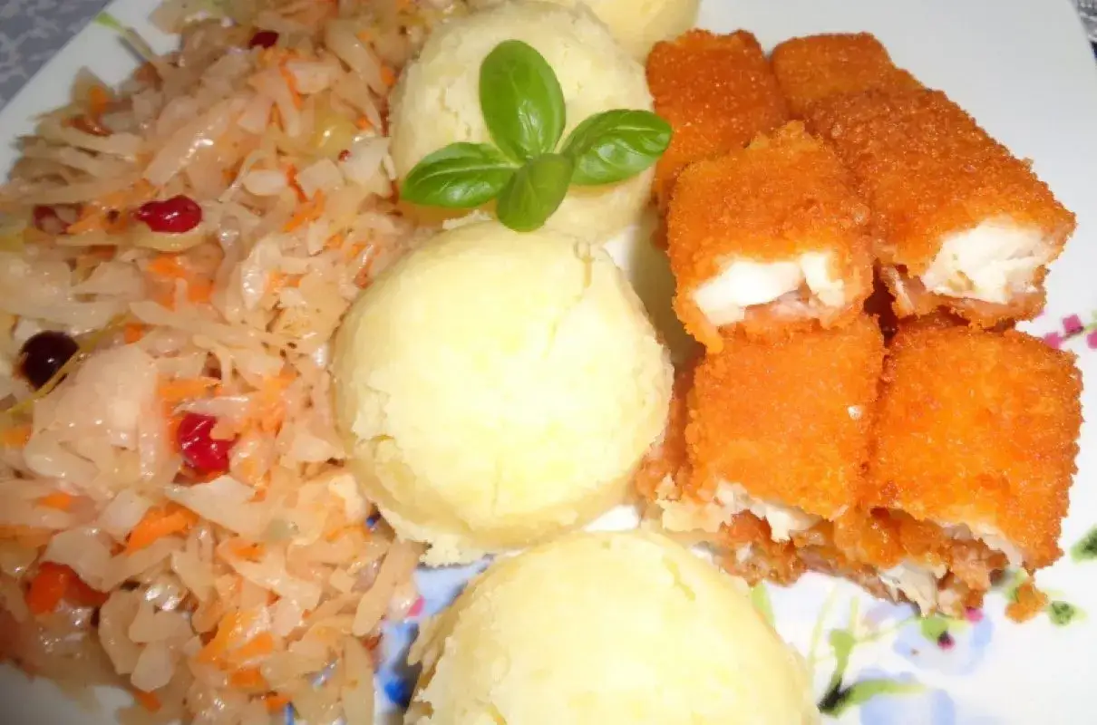 Paluszki rybne w panierce z ziemniakami i surówką z kiszonej kapusty. Pyszny pomysł na obiad, co można zrobić z paluszków rybnych.