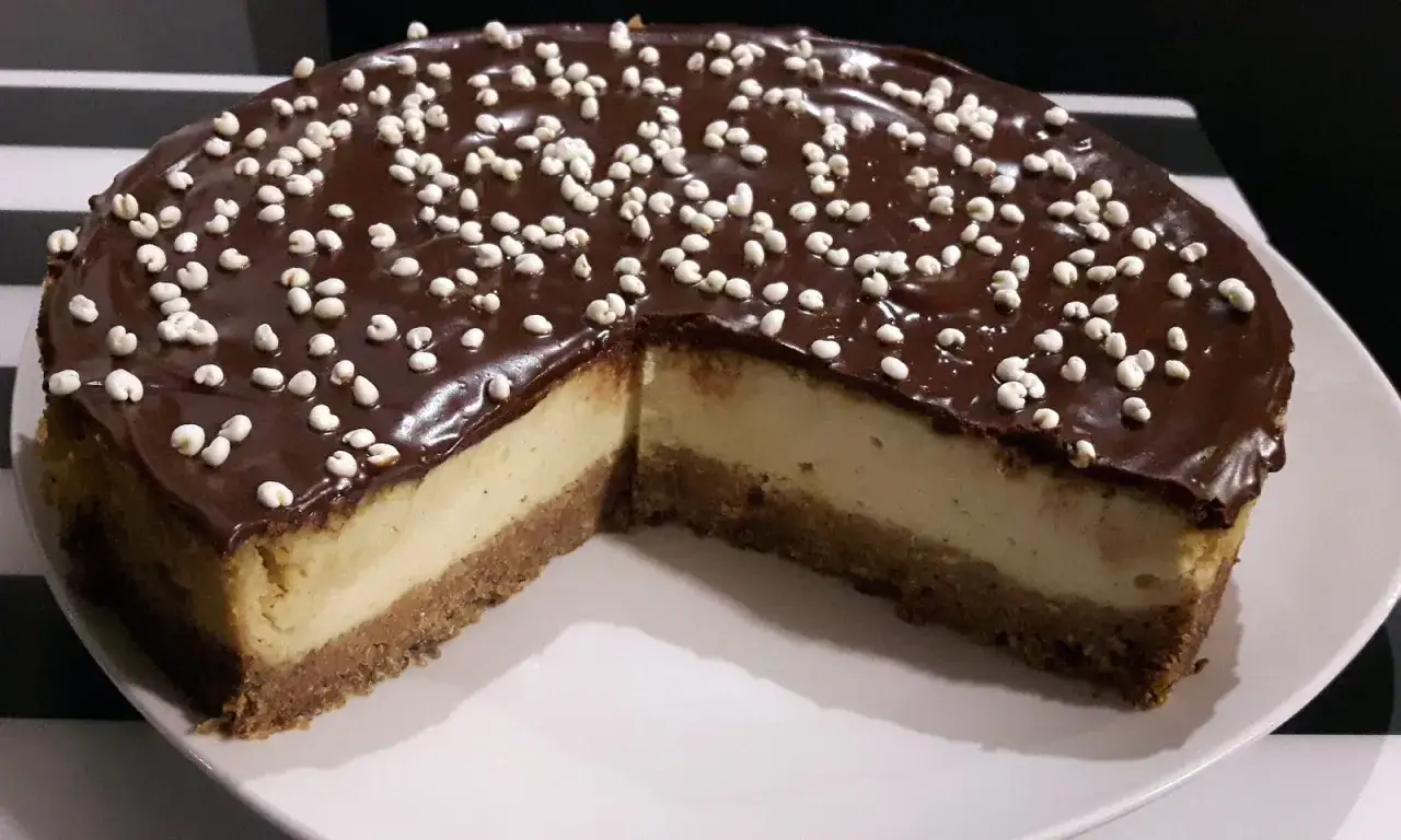 Sernik z polewą czekoladową i posypką. Ten pyszny deser, który wygląda jak tofu na słodko, zachwyca kremowym wnętrzem i kruchym spodem.