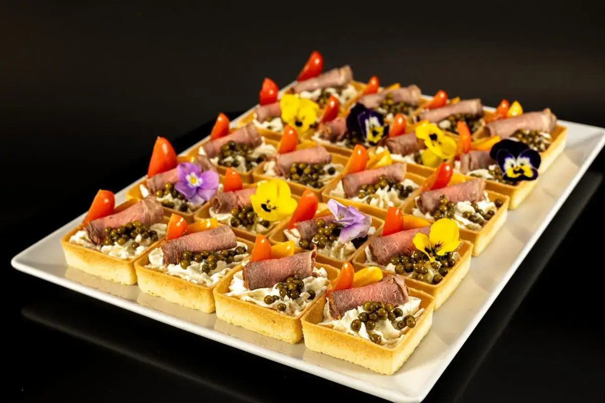 Eleganckie tartaletki z wołowiną, kawior i kwiatami. Idealne na przyjęcie, pokazują, jak zamówić catering.