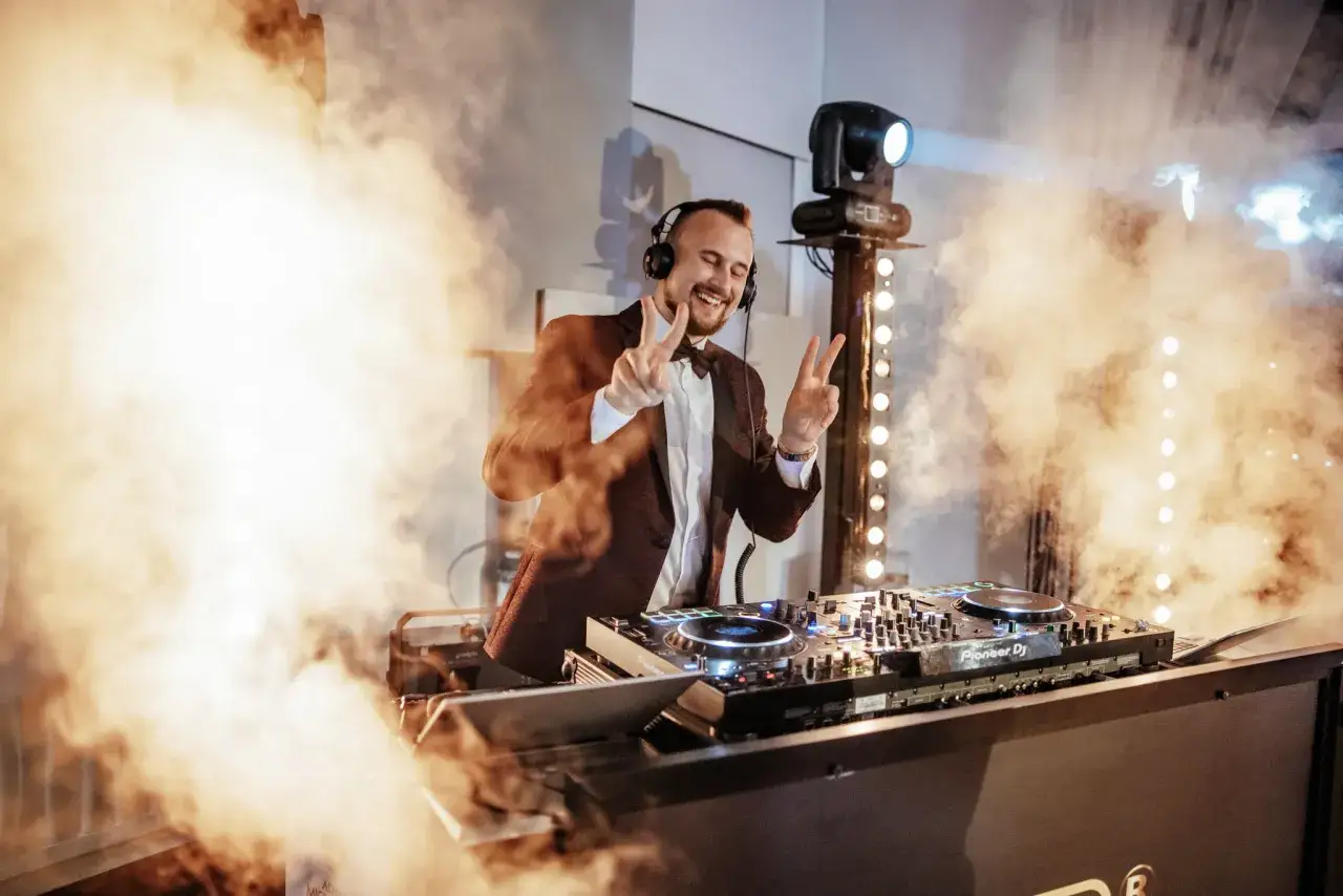 DJ w garniturze, w dymie i światłach, tworzy atmosferę. Zastanawiasz się, ile kosztuje impreza na 40 osób?