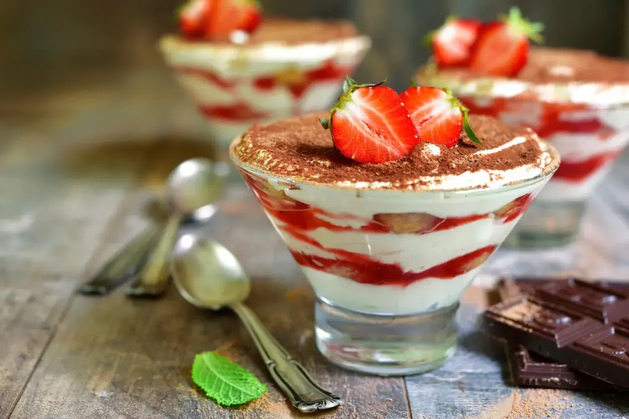 Deser z mascarpone i truskawkami, posypany kakao. Czy do serka mascarpone można dodać galaretkę? Wygląda pysznie!