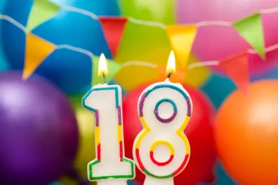 Świeczki z cyframi 1 i 8, płonące na tle kolorowych balonów i girland. Idealne na imprezę 18-stkową dla 50 osób.